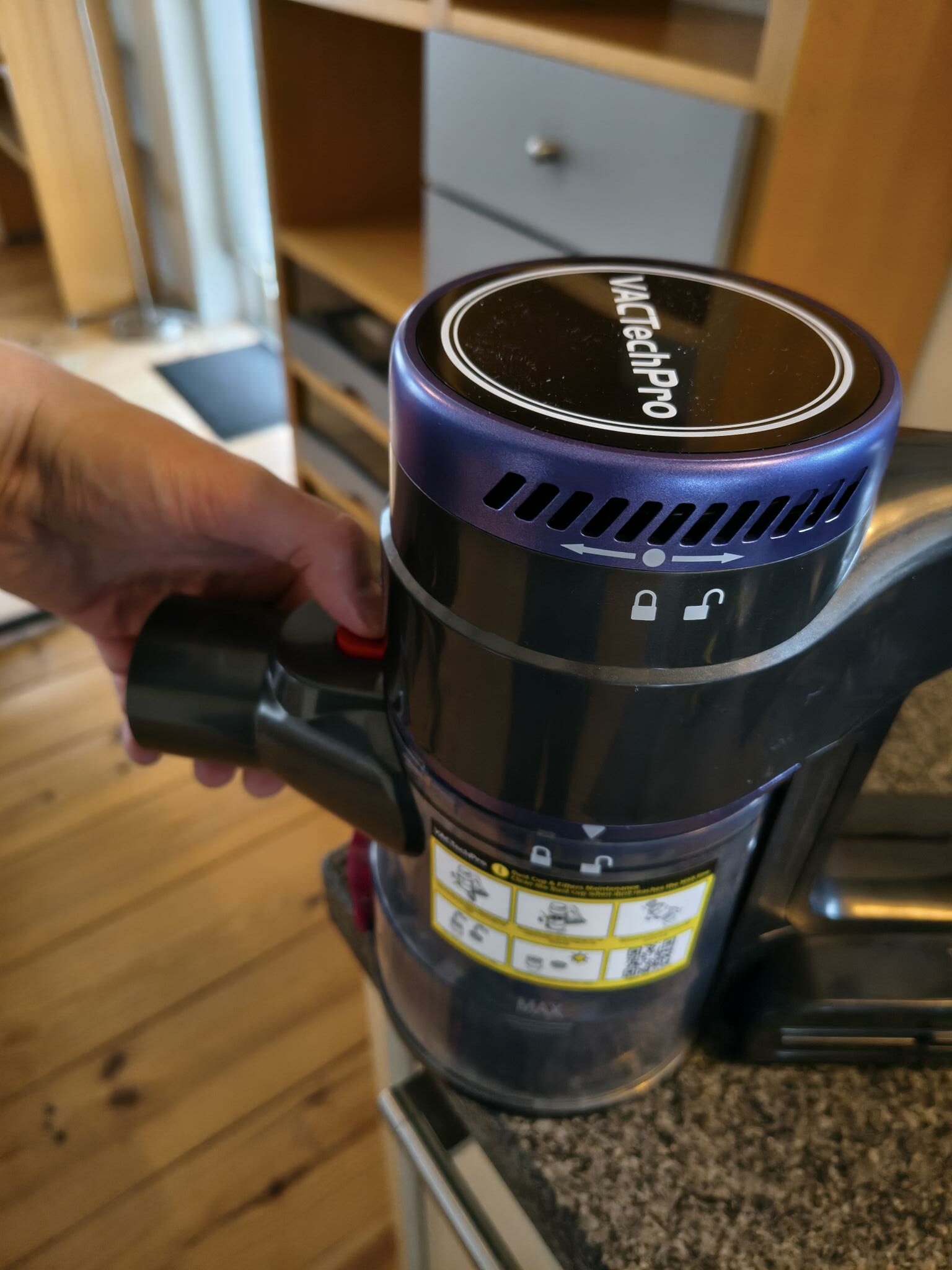 Staubbehälter entriegeln – Orientierung am offenen Schloss‑Symbol